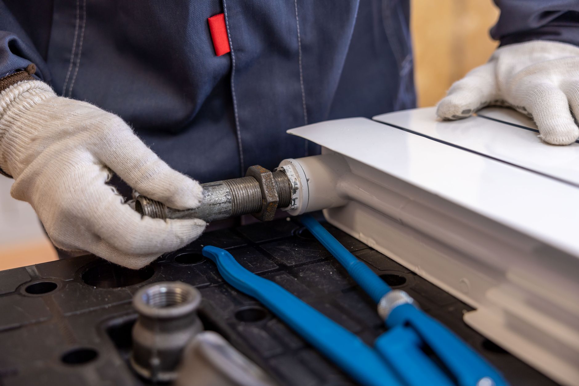 A maintenance technician repairing a fitting